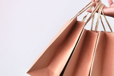 Low angle view of hand holding umbrella against white background