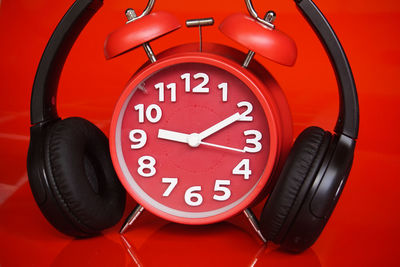 Close-up of clock against red background