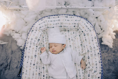 High angle view of cute baby boy sleeping on bed