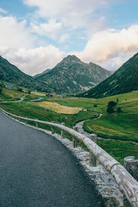 Scenic view of road by mountains against sky