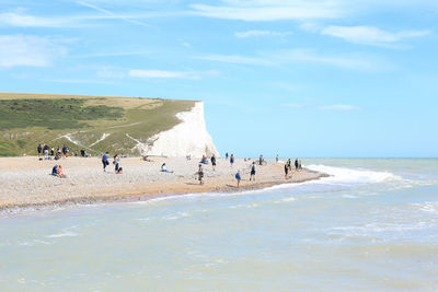 People at beach against sky