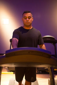 Portrait of young man sitting on table