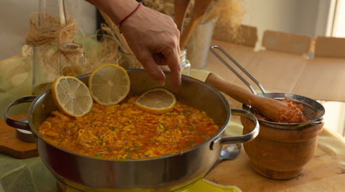 Seafood paella with lemon on kitchen table