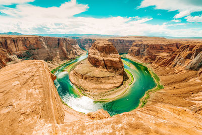 High angle view of horseshoe bend against cloudy sky