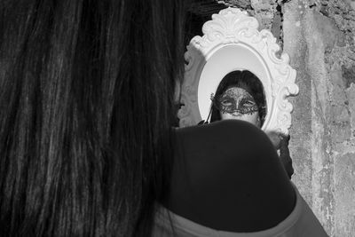 Rear view of woman with reflection on mirror