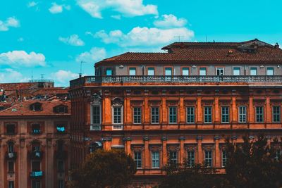 Low angle view of building against cloudy sky