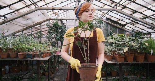 Young woman standing in greenhouse