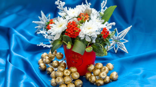 Close-up of flower vase on blue table