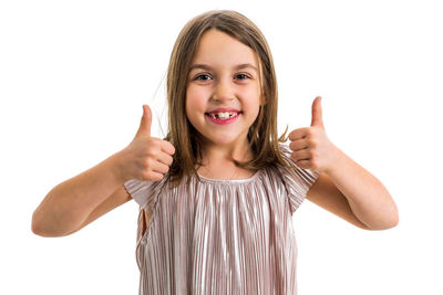Portrait of smiling girl gesturing while standing against white background