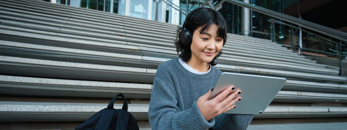 Portrait of young woman using digital tablet