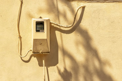 Close-up of telephone booth against wall