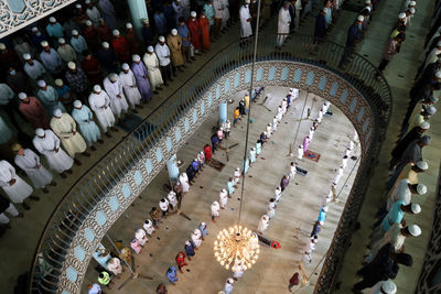 High angle view of people walking in illuminated corridor