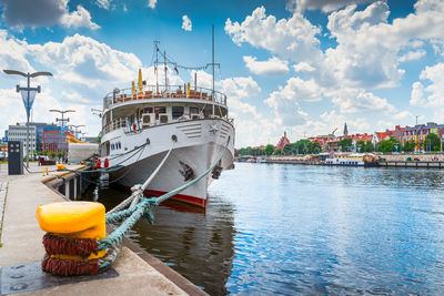 Boats moored at harbor against sky