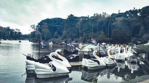 Boats moored in lake against sky