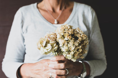 Midsection of woman holding flower bouquet