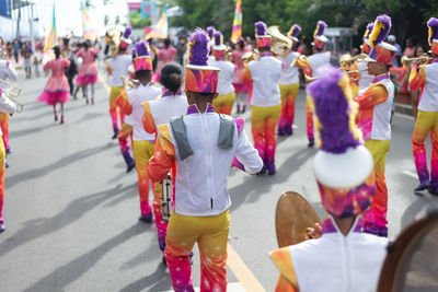 Rear view of group of musicians playing wind instruments during fuzue pre-carnival 