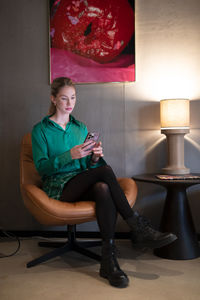 Young woman sitting on chair at home