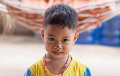 Close-up portrait of cute boy with nose injury standing outdoors