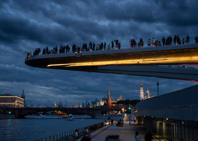 Group of people walking on bridge over river