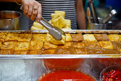 Midsection of woman preparing meat in restaurant