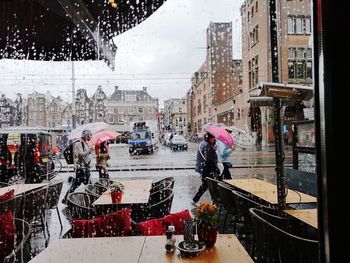 People on wet street in city during rainy season