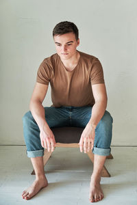 Handsome young man in t-shirt and jeans alone