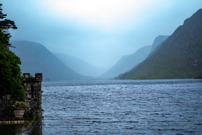 Scenic view of sea and mountains against sky