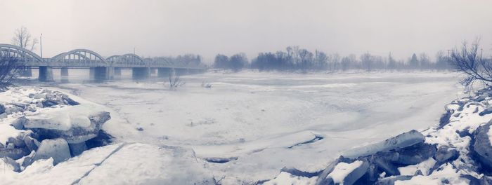 Panoramic view of frozen river against sky during winter