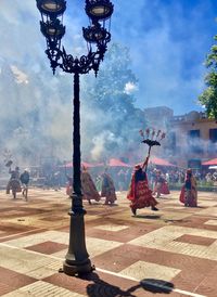 People on cross in city against sky