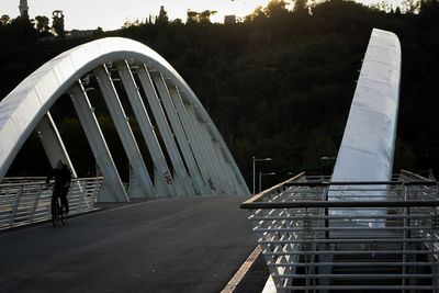 Bridge leading towards road against sky