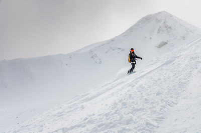 People skiing on snow covered landscape