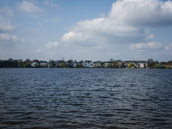 Sea by cityscape against sky