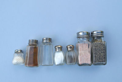 Various spices in containers on blue wall