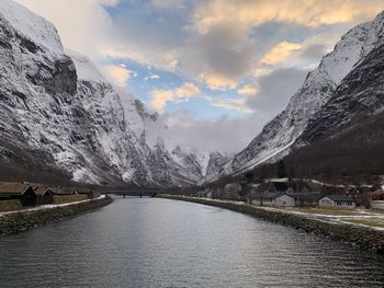 Scenic view of lake by snowcapped mountains against sky during winter