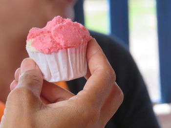 Cropped hand holding cupcake