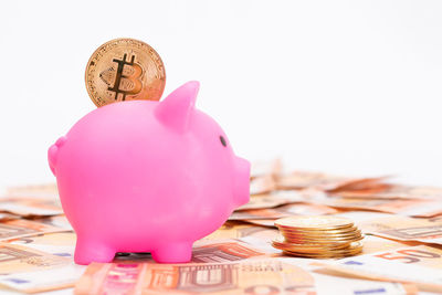 Close-up of coins and piggy bank on table