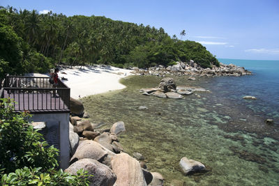 Scenic view of rocks by sea against sky