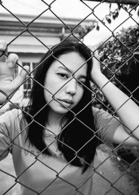 Close-up portrait of young woman in cage
