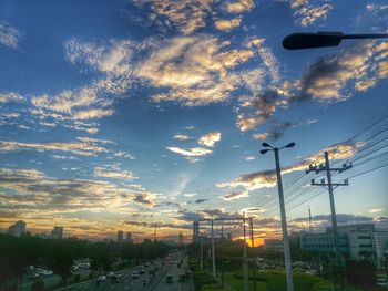 Street in city against sky during sunset