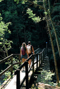 Rear view of man walking on footbridge