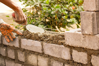 Close-up of hand holding stone wall