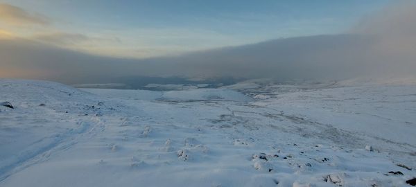 Scenic view of snow covered mountains against sky