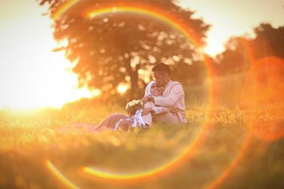 Wedding couple sitting on grassy field