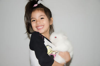 Portrait of smiling girl holding rabbit 