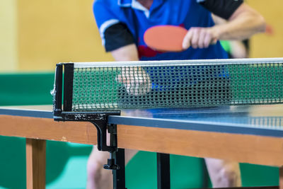 Midsection of man playing table tennis