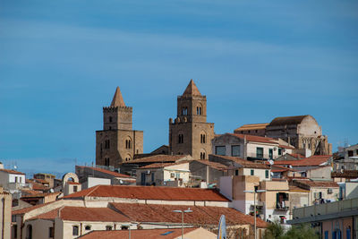 Buildings in city against blue sky