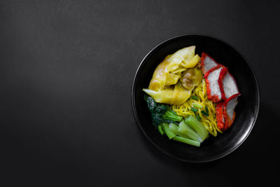 Directly above shot of salad in bowl against black background