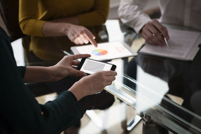 Business people at meeting in office using portabel devices