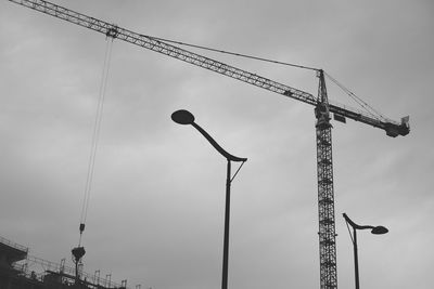 Low angle view of crane against sky