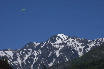 Low angle view of person against clear blue sky